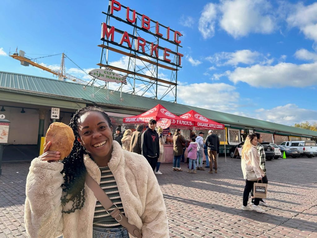 Me posing with my cookie and the public market sign 

