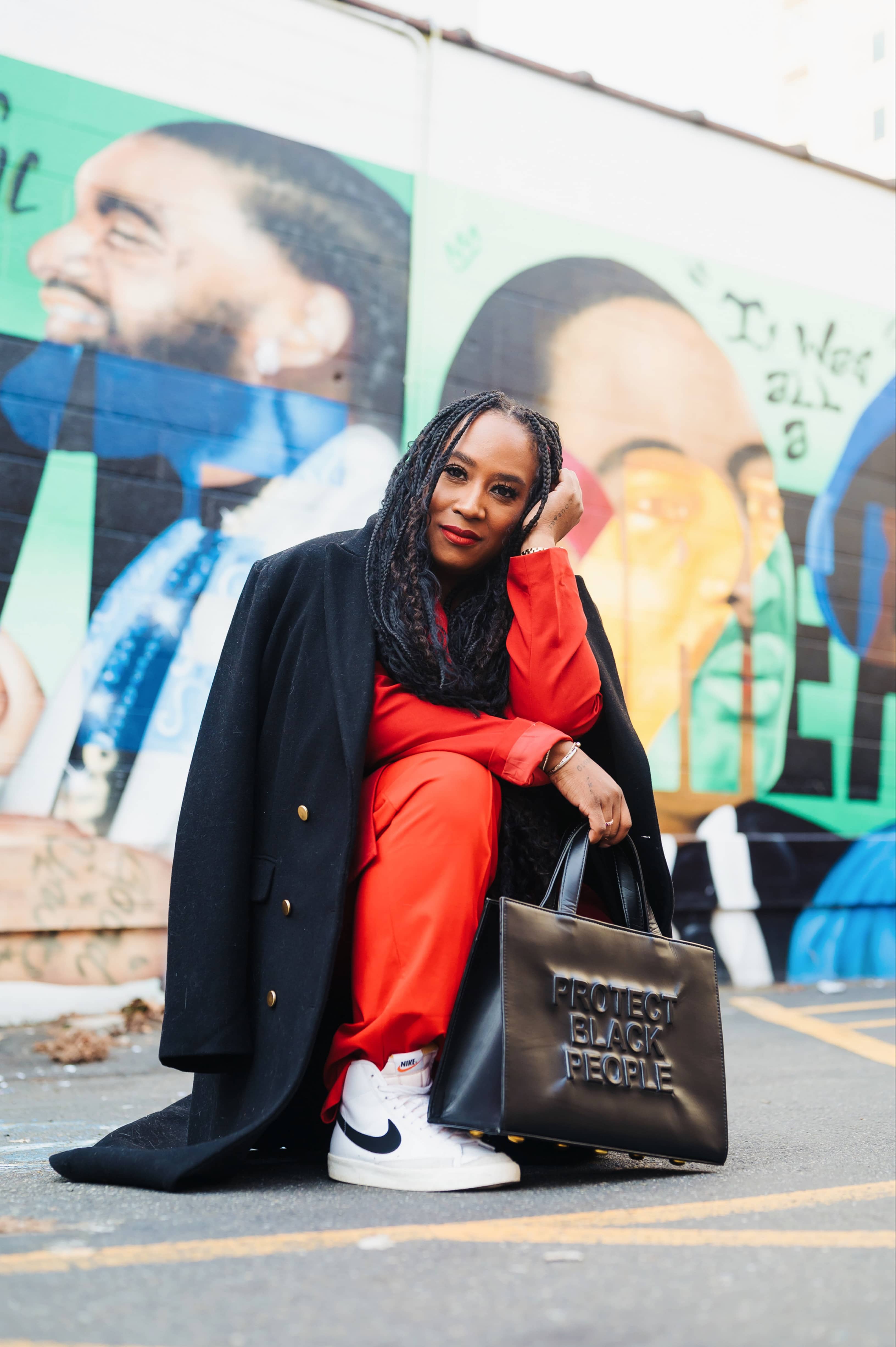 Tash of @itstashhaynes in front of a mural wearing stylish clothes