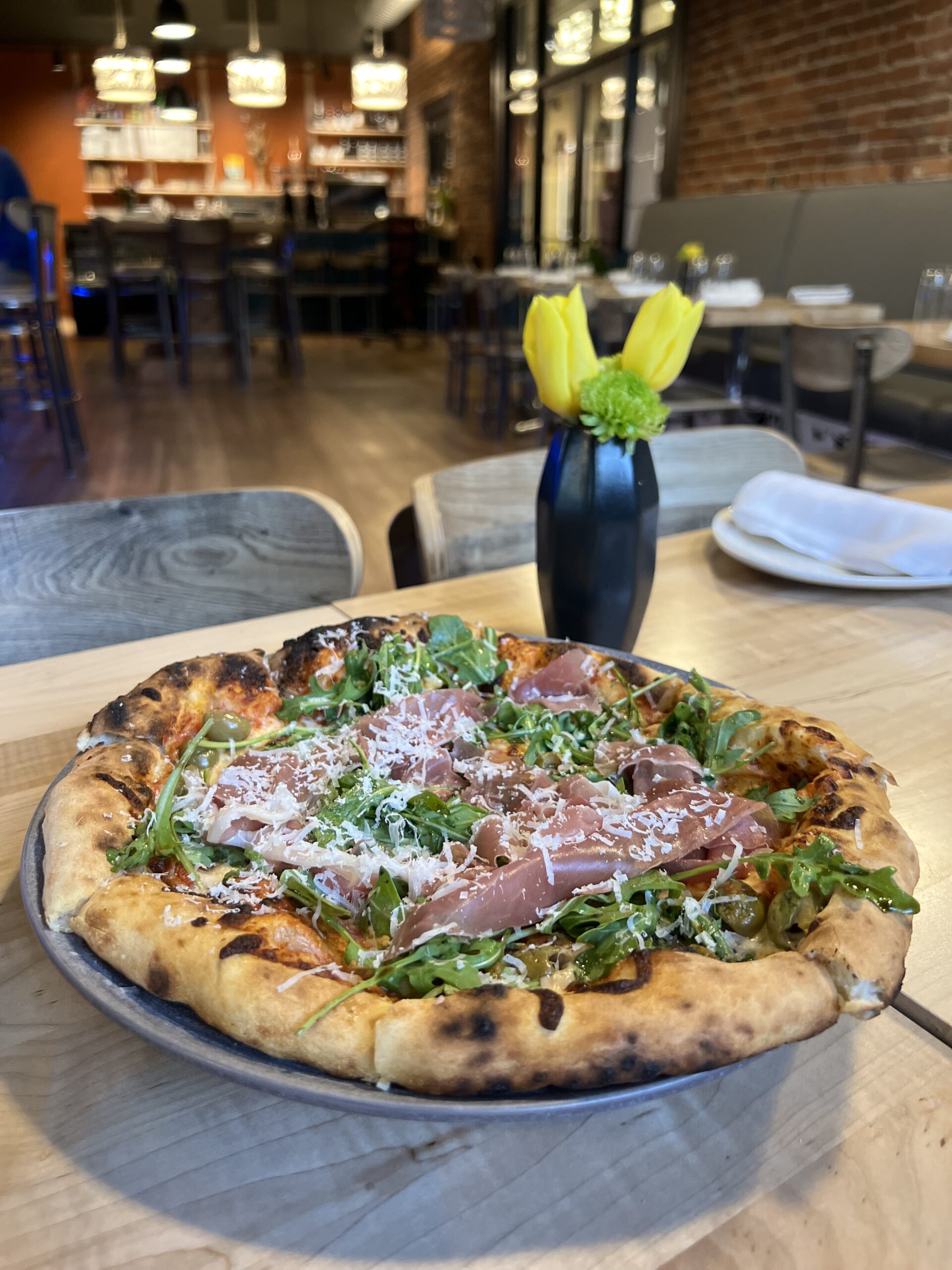 Pizza with ham and arugula on a table at Outsider in Spokane, Washington