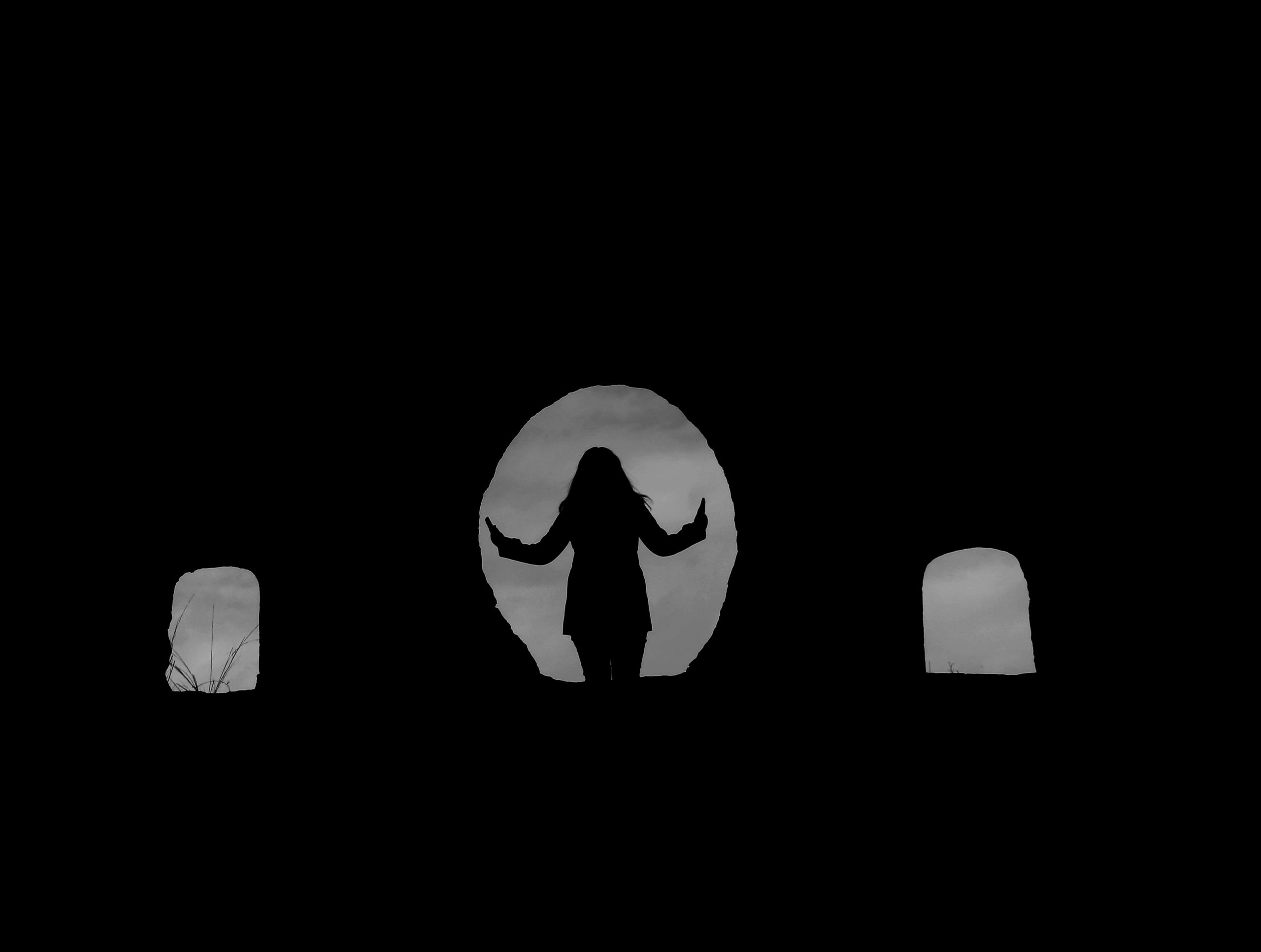 Silhouette of a woman standing in a stone archway, creating a mysterious and captivating scene.